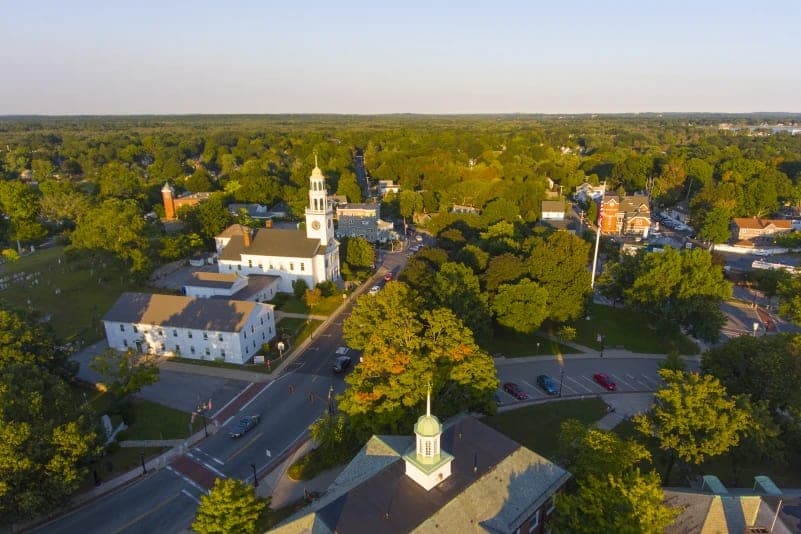 Golden-hour aerial of the Reading MA town common and white church steeple
